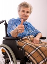 3303730-ritratto-di-una-donna-anziana-in-sedia-a-rotelle-che-il-pollice-fino-segno
